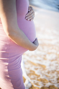 Midsection of woman standing at beach