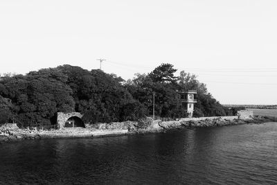 Building by river against clear sky