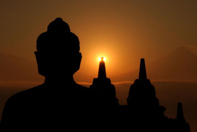 Silhouette of statue against sky during sunset