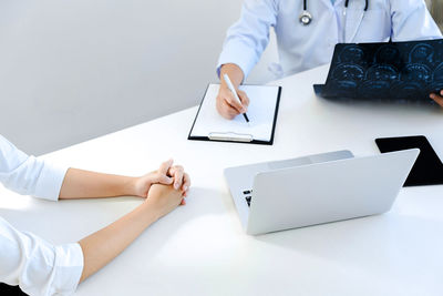 Low angle view of people using laptop on table