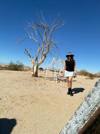 Full length of man standing on street against clear sky