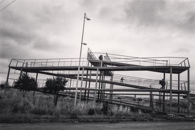 Cranes against cloudy sky