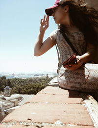 Young woman standing against clear sky