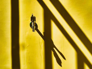 Close-up of closed metal against wall during sunny day