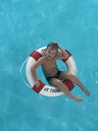 High angle view of boy swimming in pool with lifebuoy