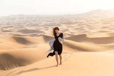 Full length of man on sand dune in desert