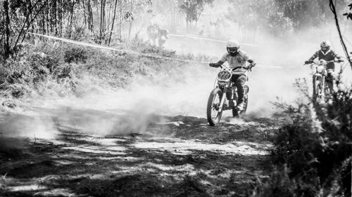 Men riding dirt bike on road