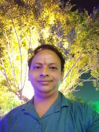 Portrait of smiling man standing against plants
