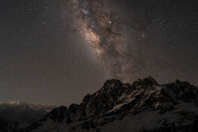 Scenic view of snowcapped mountains against sky at night