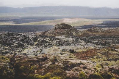 Surface level of barren landscape against mountain range