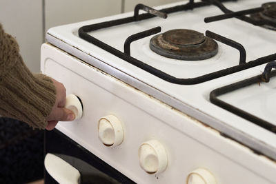 Woman checking gas. female hand trying to turn on old gas stove. no gas, winter and cold period