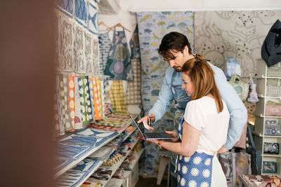Serious owners using laptop in fabric shop