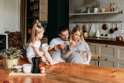 A happy cheerful family with a child is cooking dinner together in the kitchen at home