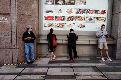 People standing against wall