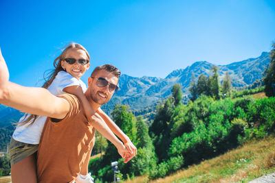 Portrait of smiling woman with sunglasses against sky