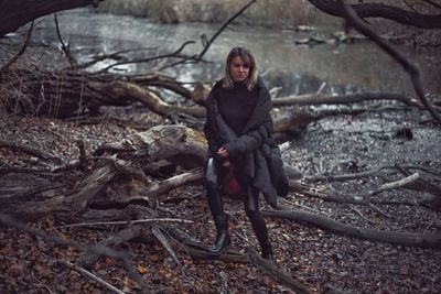 Portrait of young woman standing in forest