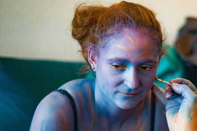 Portrait of young man with multi colored face