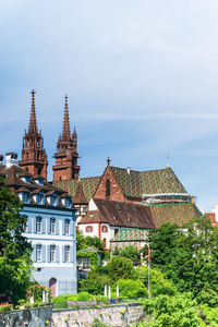 Church and trees in city against sky