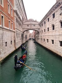 Gondoliers sailing towards bridge of sighs over canal