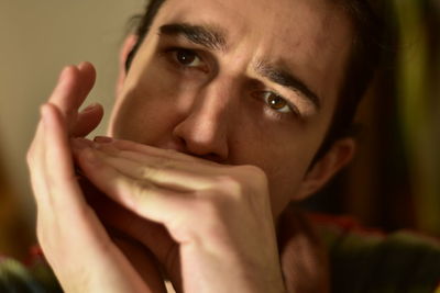 White caucasian male playing harmonica at home passionately