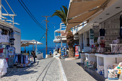 Tourists and locals at the stores on the beautiful alleys of fira city in the island of santorini