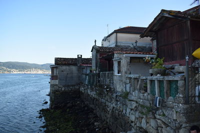 Abandoned building by sea against clear sky