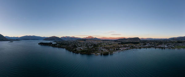 Aerial view of townscape by sea against sky