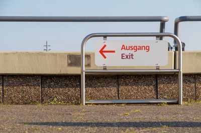 Information sign on road against sky