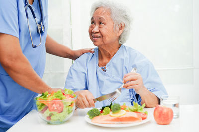 Midsection of doctor examining patient at home