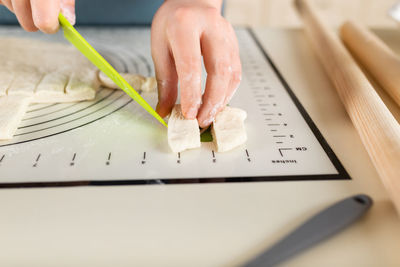 Cropped hand writing in book on table