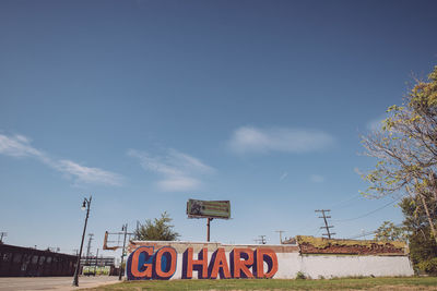 View of road sign against blue sky