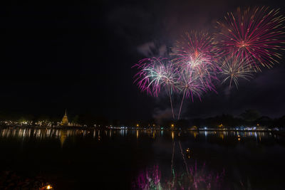 Firework display over river at night