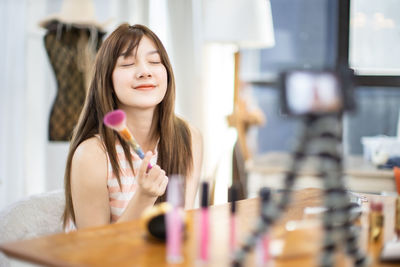 Portrait of a teenage girl holding table