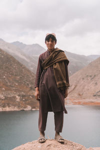 Portrait of man standing on mountain against sky