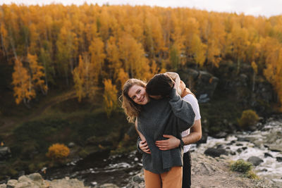 Happy people in love are travel hike in nature in the autumn forest. romantic trip to countryside