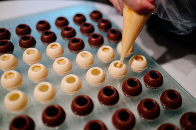 Hand filling pralines with chocolate