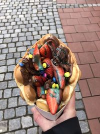 Midsection of person holding ice cream on street