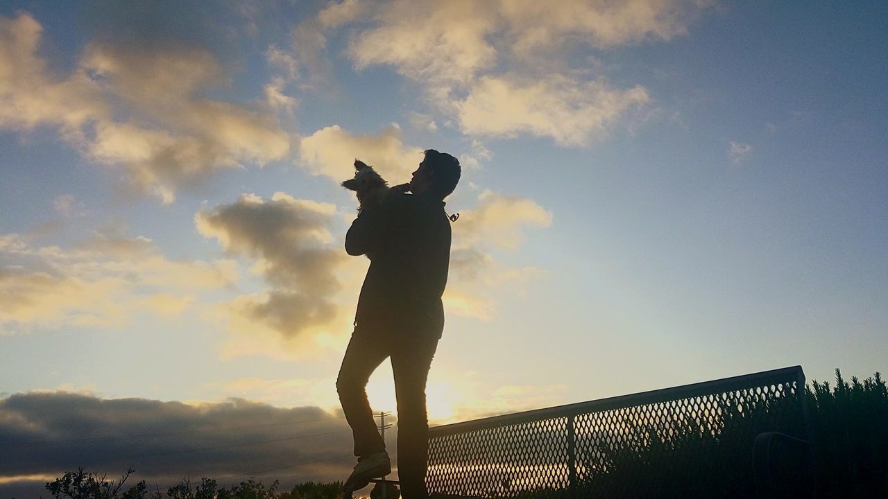 LOW ANGLE VIEW OF SILHOUETTE MAN STANDING AT SUNSET