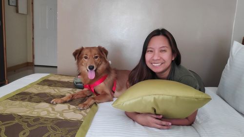 Portrait of young woman with dog at home