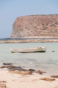 Nautical vessel on sea shore against clear sky