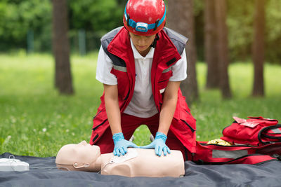 Healthcare worker practicing on cpr dummy at park