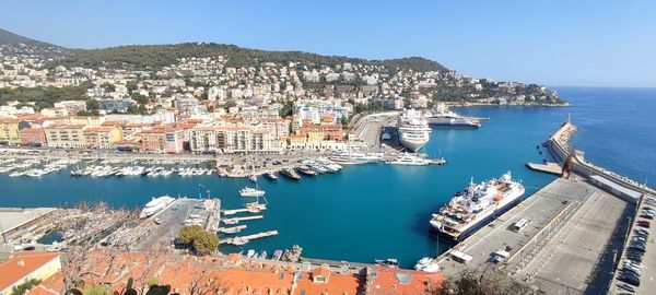 High angle view of townscape by sea against clear sky