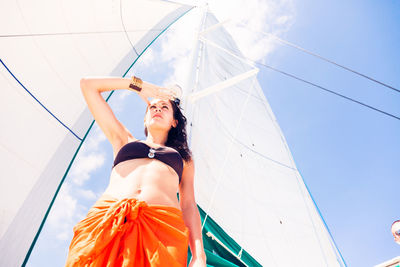 Low angle view of woman standing against sky