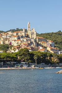 View of buildings by sea against clear sky