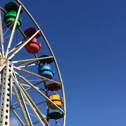 Low angle view of ferris wheel against blue sky