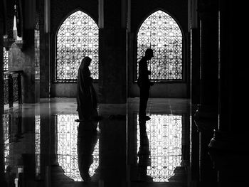 Silhouette woman standing by window in building