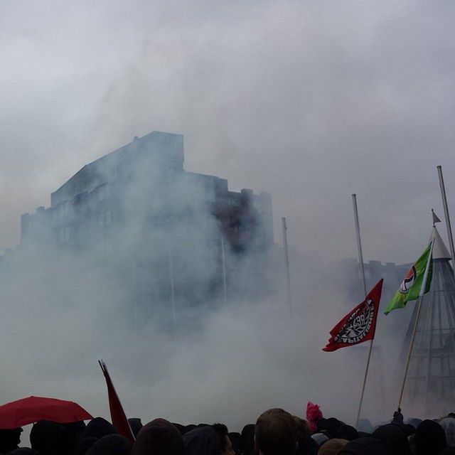 sky, cloud - sky, flag, cloudy, weather, transportation, cloud, large group of people, outdoors, patriotism, smoke - physical structure, men, overcast, mountain, travel, mode of transport, building exterior, low angle view, built structure