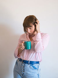 Woman holding coffee cup against white background