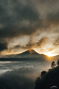 Scenic view of mountain against cloudy sky during sunset