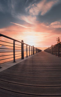 Pier over sea against sky during sunset